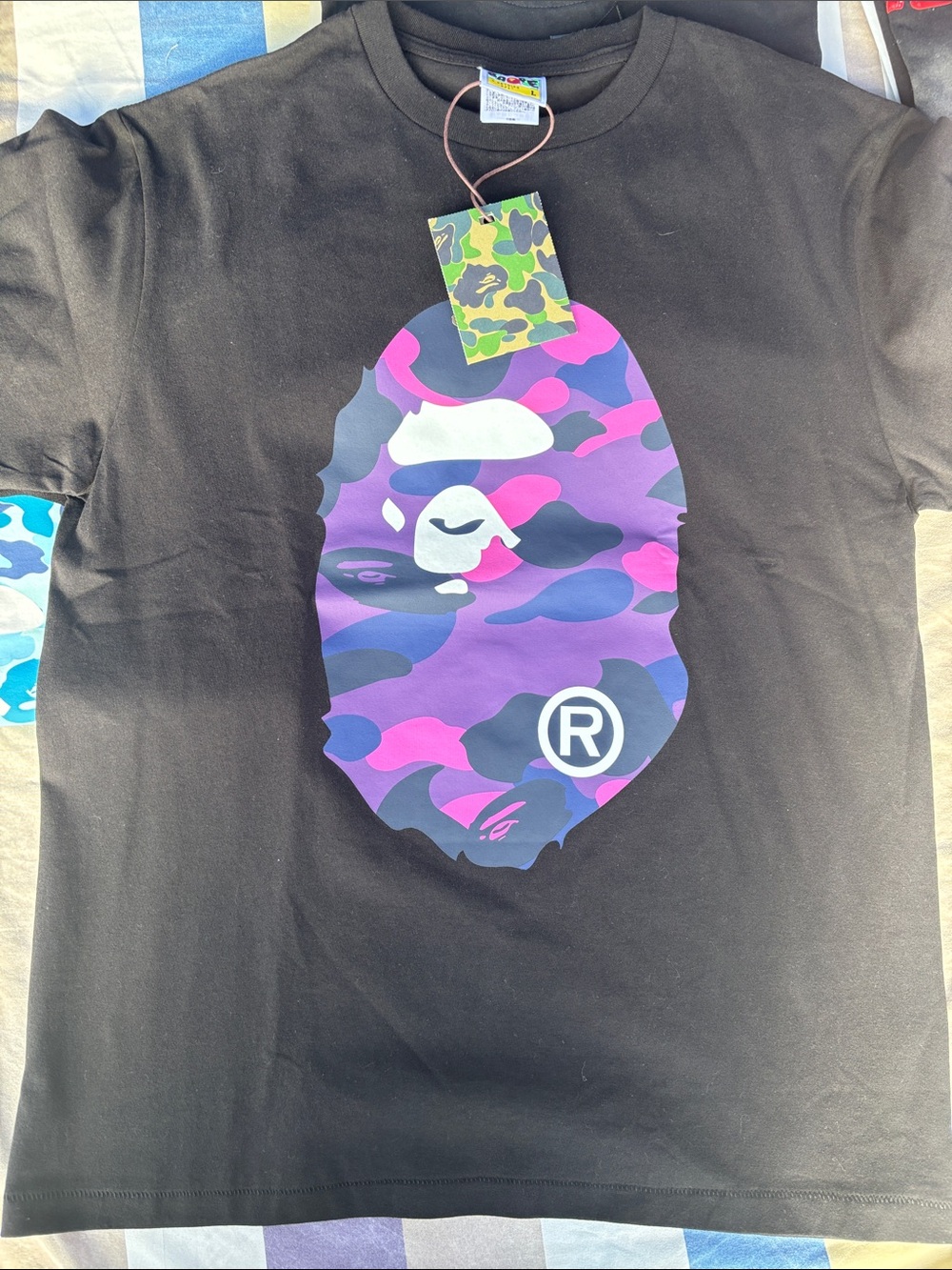 BAPE means ' Black Tee with Purple & Pink Camo Ape Logo